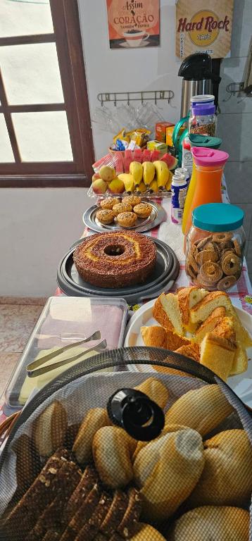 a table topped with lots of different types of food at Suíte Trilha do Sol 2 in Arraial do Cabo