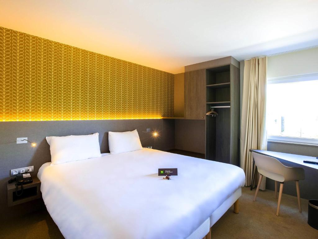 Un pat sau paturi într-o cameră la ibis Styles Kortrijk Expo