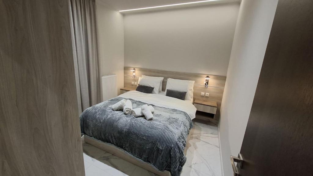 a bedroom with a bed with two stuffed animals on it at K & V apartments in Amfiklia