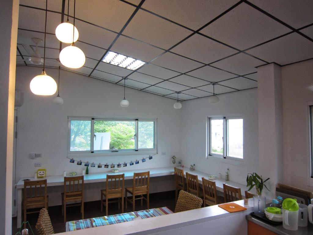 a dining room with a long table and chairs at Amy Walker B&B in Taimali