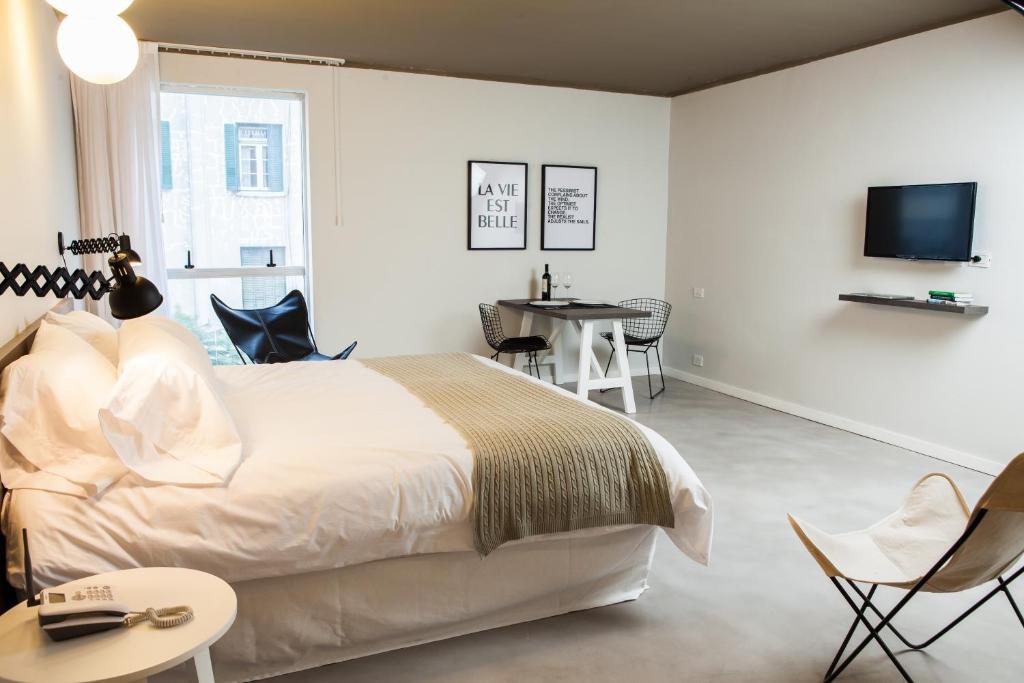 a white bedroom with a bed and a table and chairs at Babel Studios in Buenos Aires