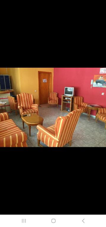 a living room with chairs and a table and a tv at Tenerife Hostel in Los Cristianos