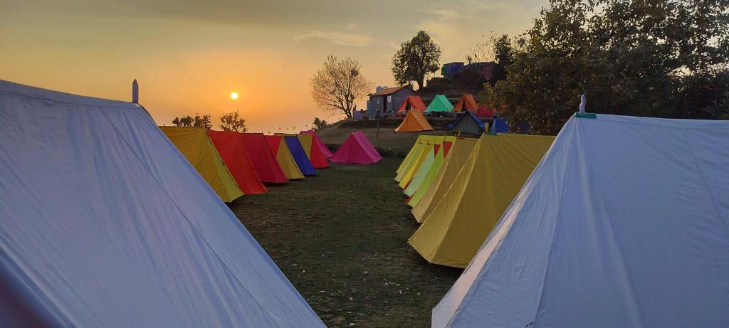 eine Reihe bunter Zelte mit dem Sonnenuntergang im Hintergrund in der Unterkunft Nagtibba Trek - Three Sixty Views in Miānī