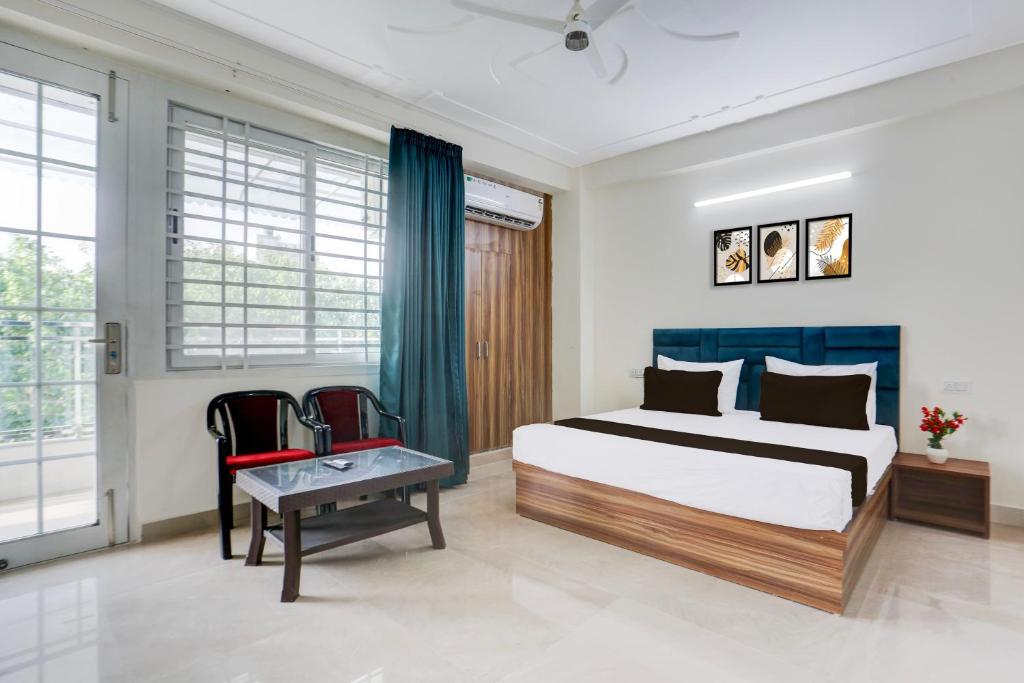 um quarto com uma cama king-size e 2 cadeiras em Hotel O THE AEROSITY em Nova Deli