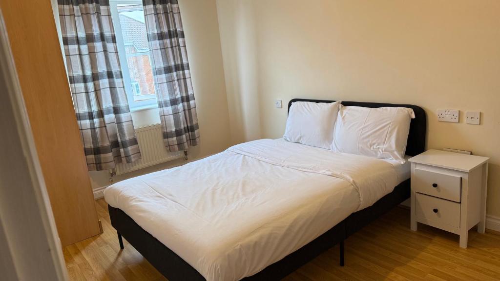 Schlafzimmer mit einem Bett, einem Nachttisch und einem Fenster in der Unterkunft Wilmer House in Eastleigh