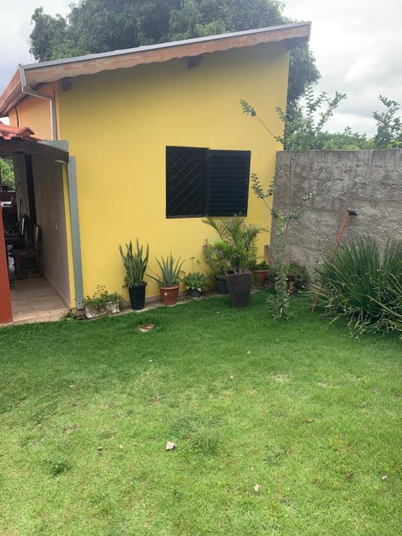 una casa gialla con una finestra in un cortile di Recanto Pedrita a Pedreira