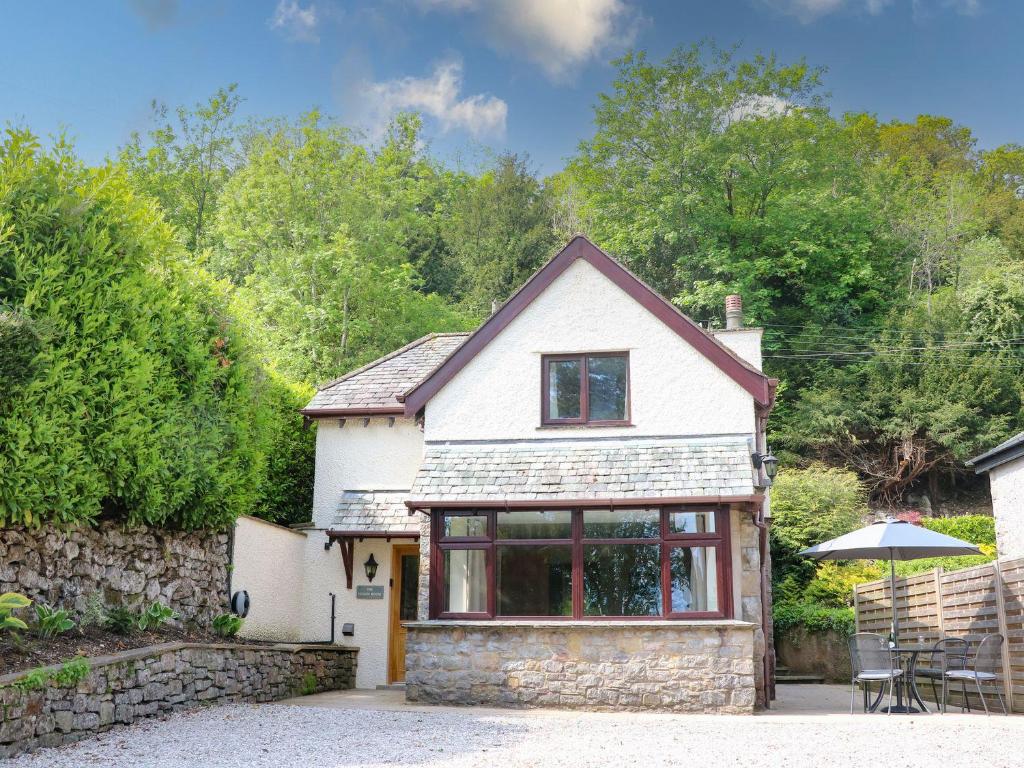 a small white house with a stone wall at The Coach House in Carnforth