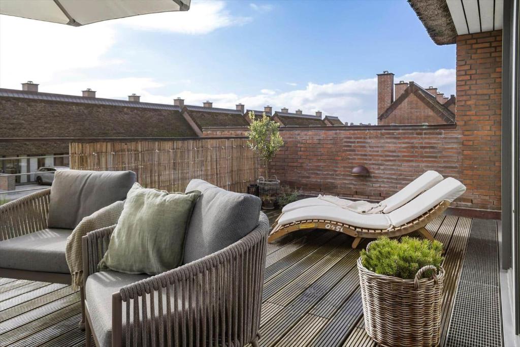 a patio with two chairs and a couch on a deck at 1900-Romo-Klitrosevej-40 in Sønderby