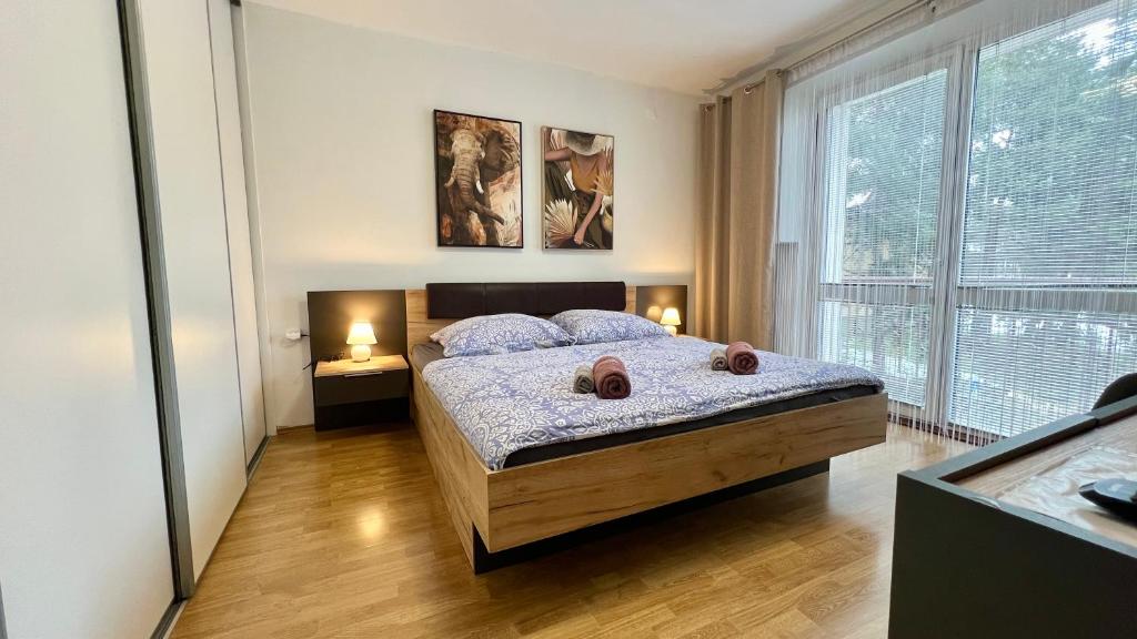 a bedroom with a bed and a large window at Black Lotus 1 I Downtown Apartment I Free Parking I 24hr Access in Banská Bystrica