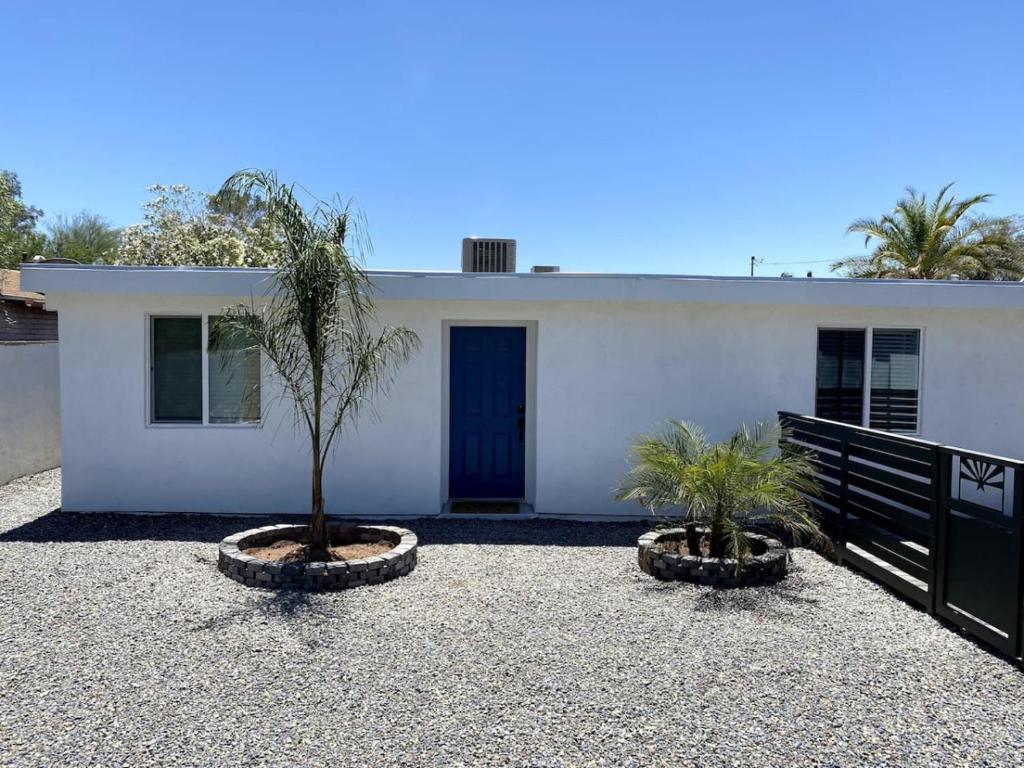 a white house with two palm trees in front of it at E 1st Back Casita in Tucson