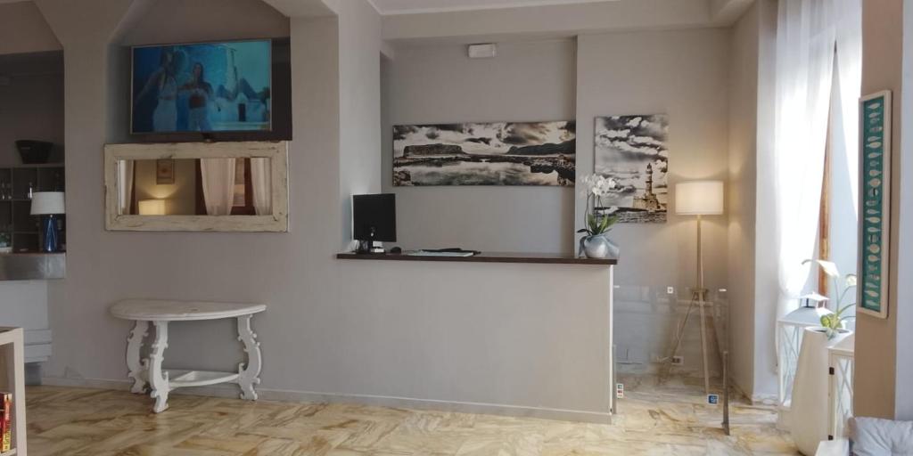 ein Wohnzimmer mit weißen Wänden und einem Tisch in der Unterkunft Hotel Sole in Orbetello