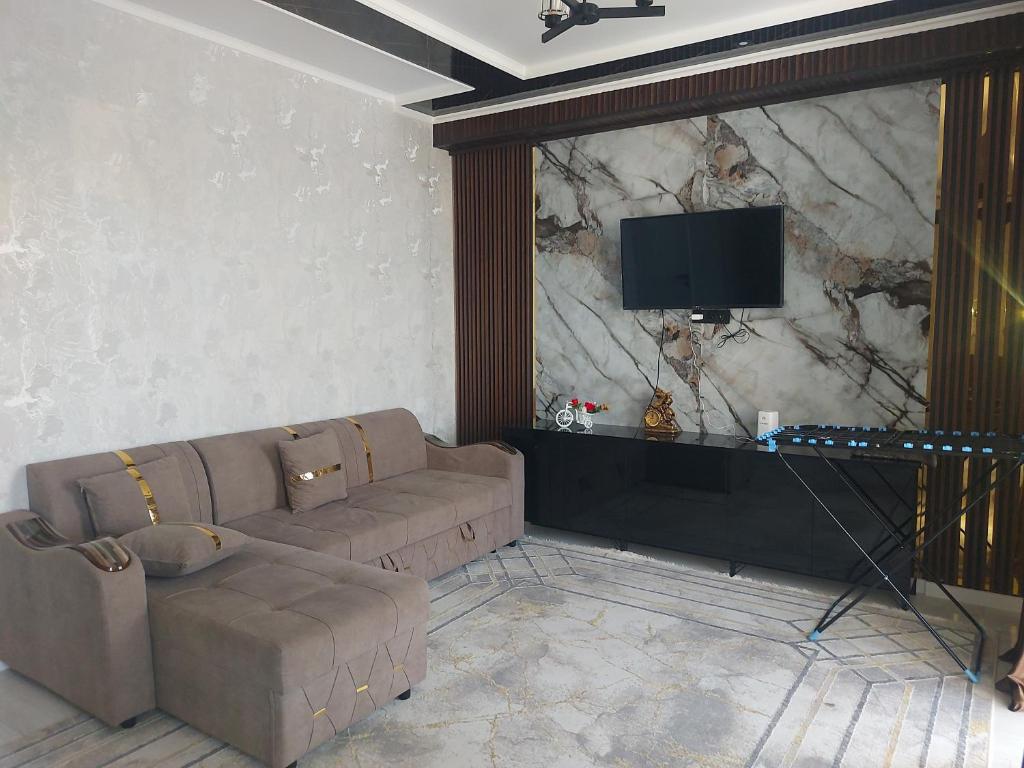 ein Wohnzimmer mit Sofa und Flachbildfernseher in der Unterkunft КАРАВАН САРАЙ 15 Венеция in Türkistan