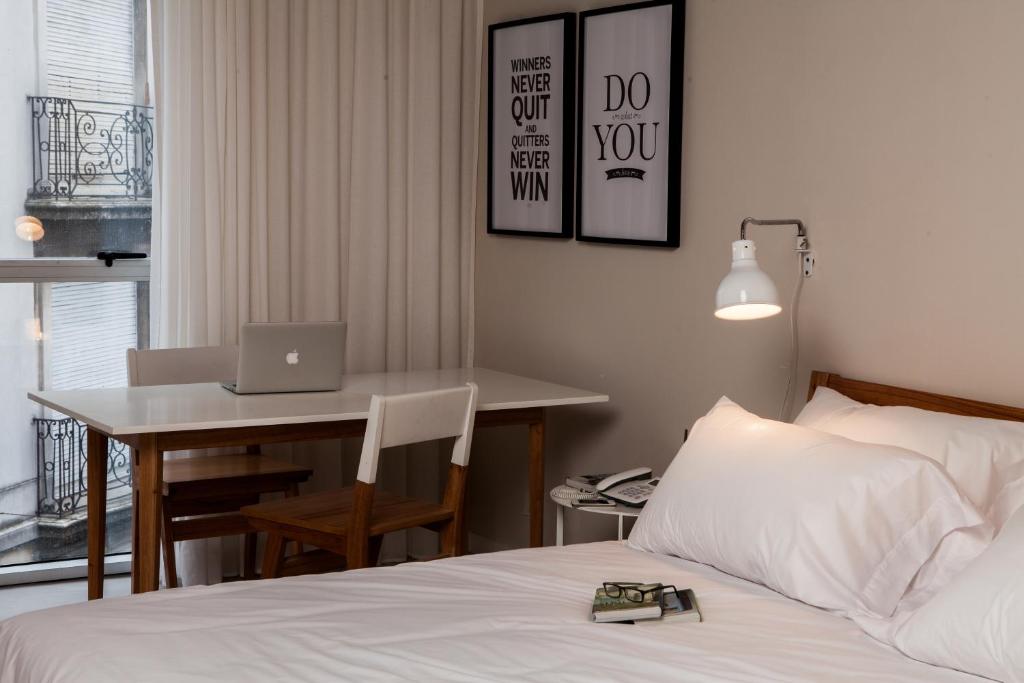 Un dormitorio con una cama y un escritorio con una computadora portátil. en Babel Studios, en Buenos Aires