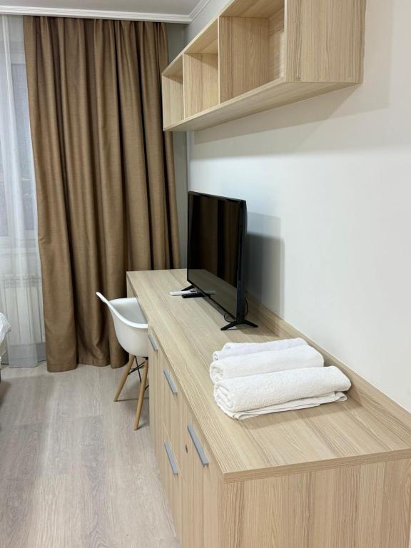 a room with a desk with a flat screen tv at Yes apart hotel in Astana