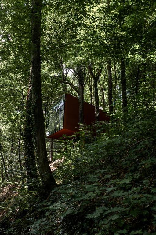 a red object sitting in the middle of a forest at Hortensia 7 in La-Roche-en-Ardenne