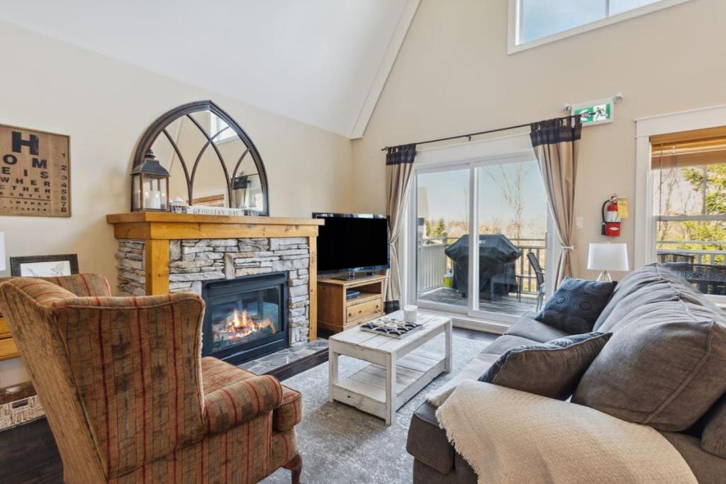 a living room with a couch and a fireplace at 225 Snowbridge with Village Shuttle in Collingwood