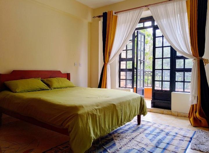 Turquoise Haven في نيروبي: غرفة نوم بها سرير ونافذة كبيرة