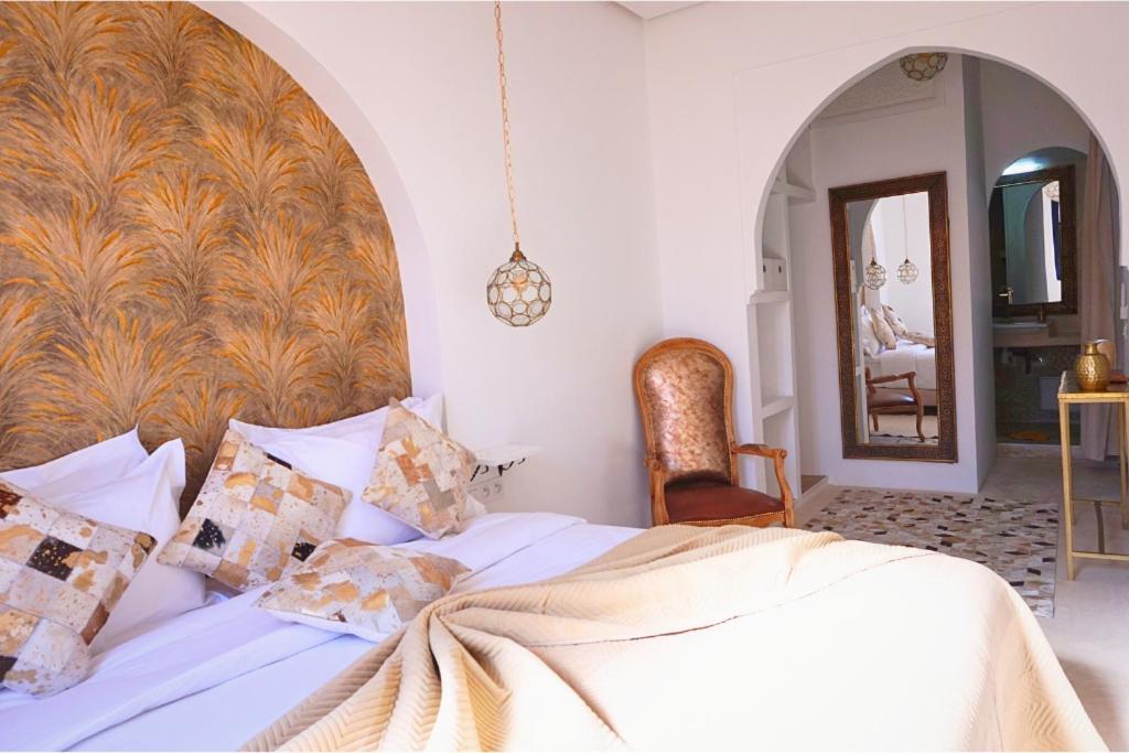 a bedroom with a white bed with a large headboard at Little date in Marrakech