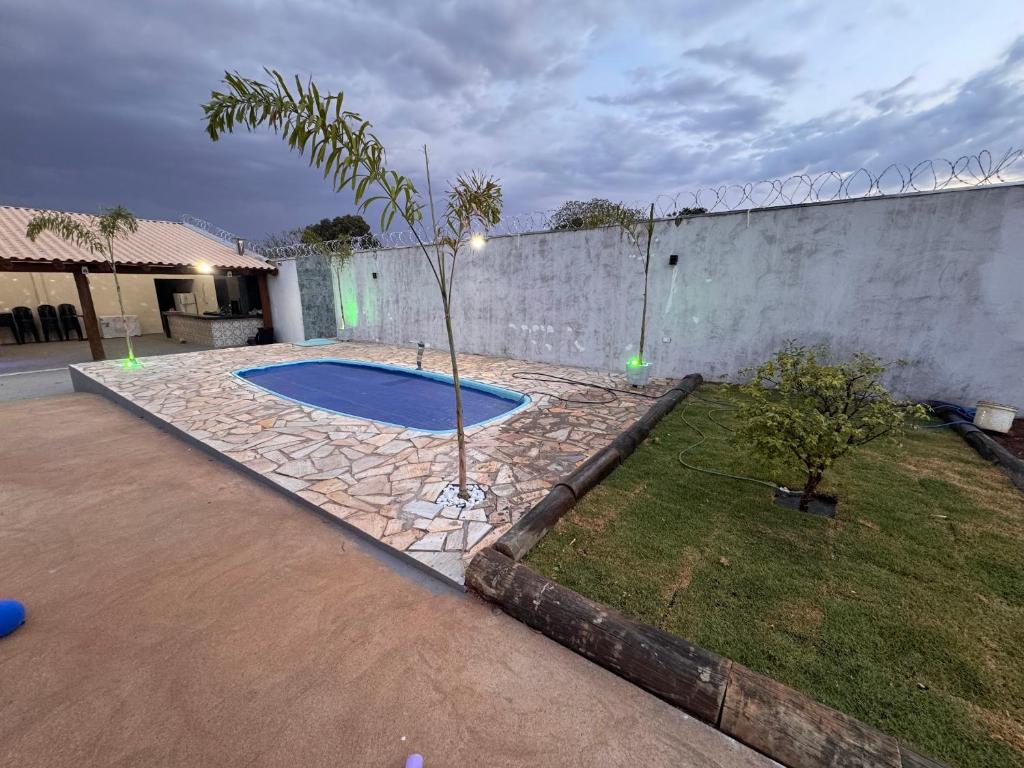a small tree in a yard next to a wall at Chácara Tubaras in Uberlândia