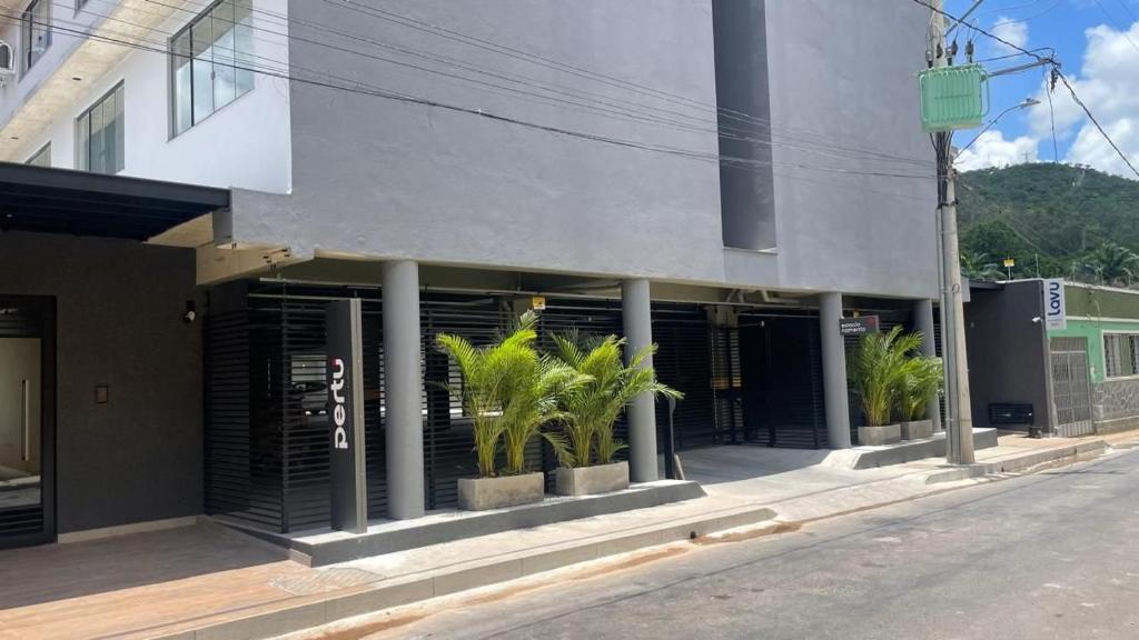 ein Gebäude mit Palmen davor in der Unterkunft Studios super modernos, completos e equipados no centro de Pará de Minas in Pará de Minas