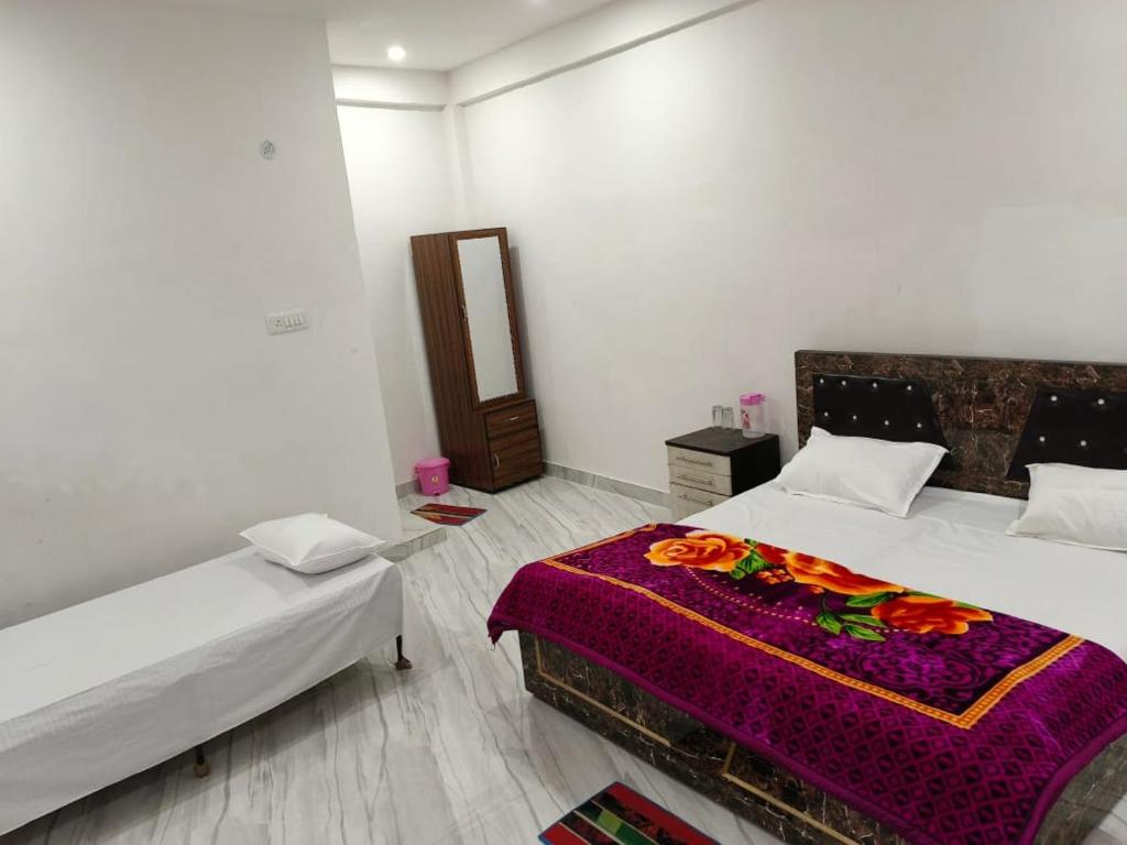 a bedroom with two beds and a mirror in it at Manglam House in Ayodhya
