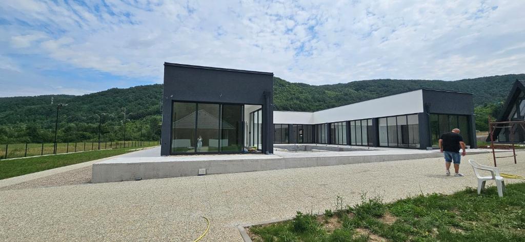 a man standing in front of a black and white building at Golden Spa Villa in Bihać
