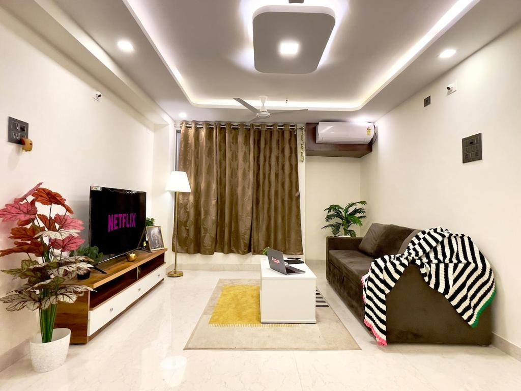 a living room with a couch and a tv at Breezy Brown Spacious 2 BHK Lake View in Mumbai