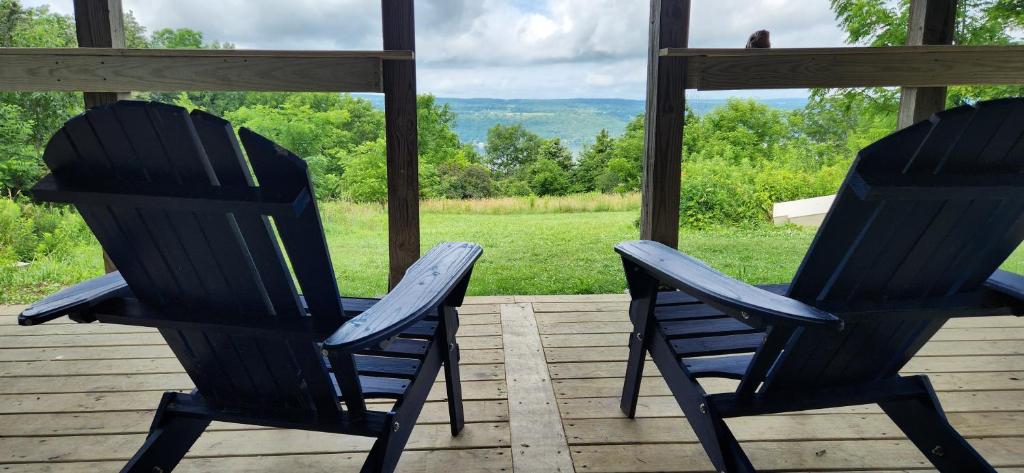 2 chaises assises sur une terrasse couverte donnant sur un champ dans l'établissement Morabeza - A Tropical Seneca Haven, à Burdett