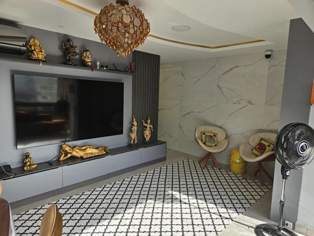 Μια τηλεόραση ή/και κέντρο ψυχαγωγίας στο Apartamento moderno e sofisticado perto da praia