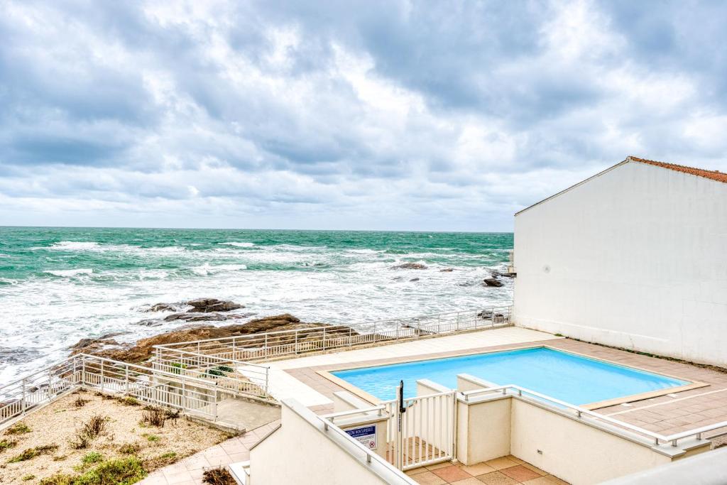 a view of the ocean from the balcony of a house at Studio Premium Face Océan, Balcon & Piscine in Les Sables-d'Olonne
