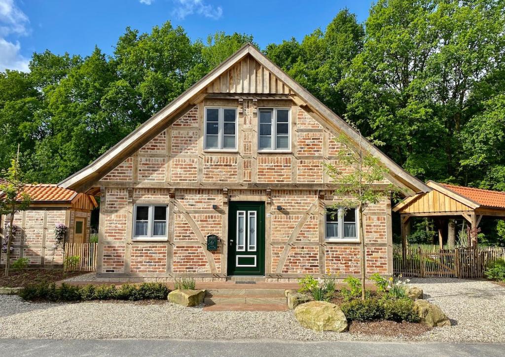 een klein bakstenen huis met een groene deur bij Ferienhaus Waldblick in Warendorf