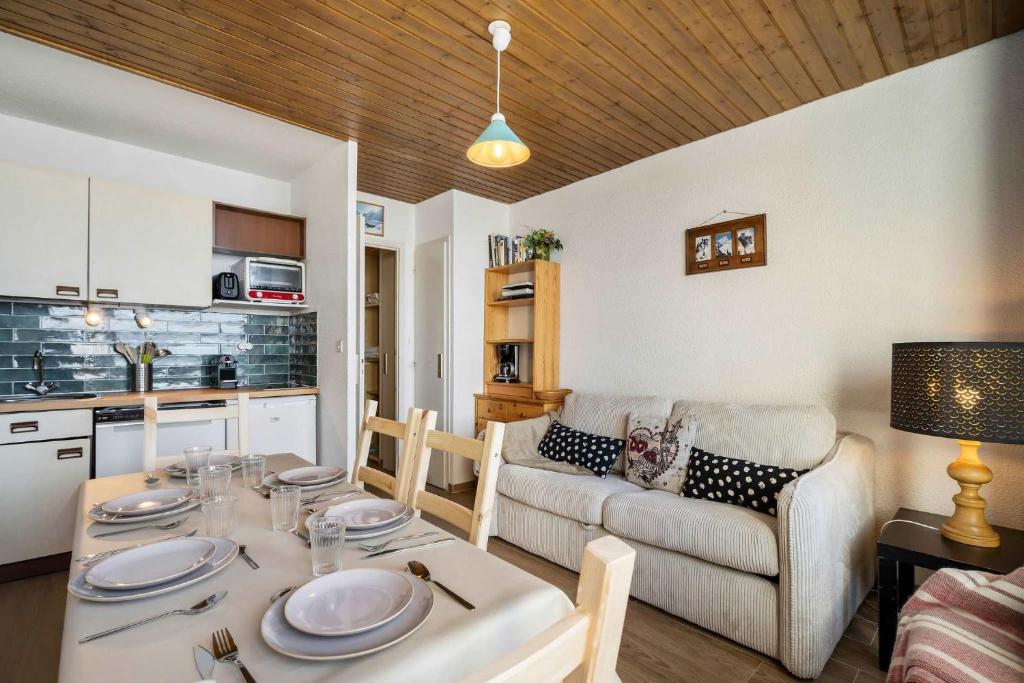 a kitchen and living room with a table and a couch at Ski-in Chalet-Style View Flat - Résidence les Eterlous in Val Thorens
