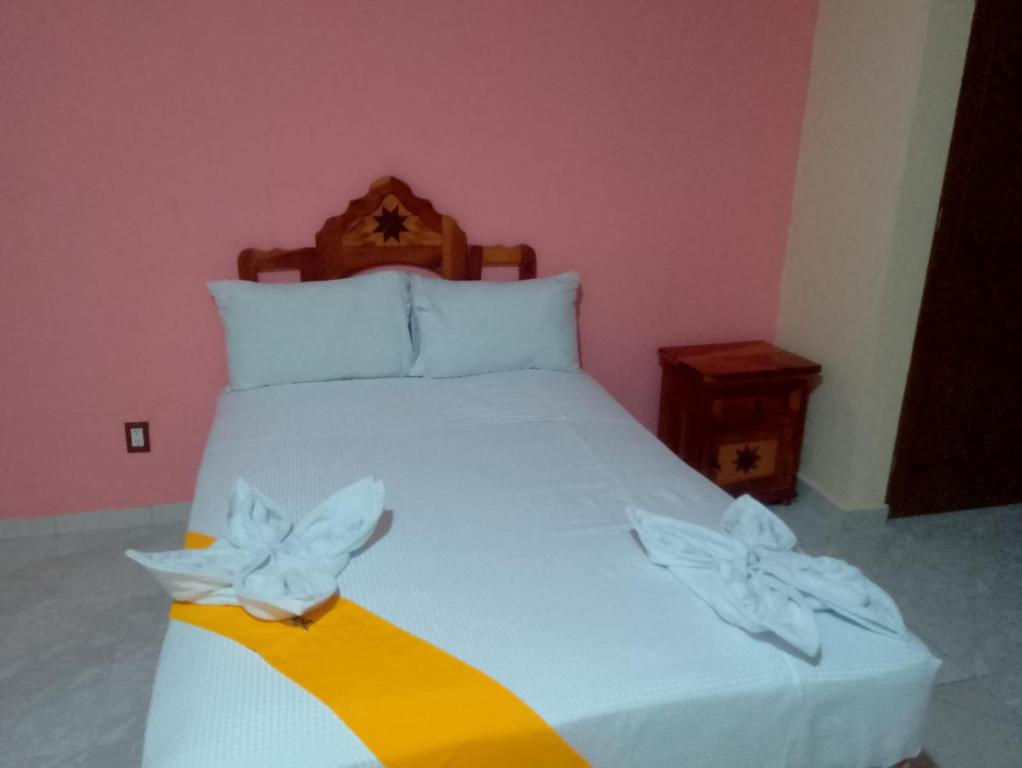 a bedroom with a white bed with flowers on it at Ch Aeropuerto Cuernavaca in Temixco