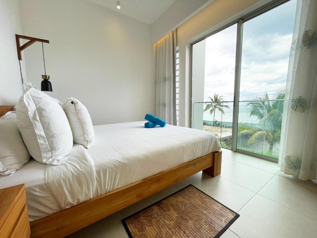 a bedroom with a bed with a view of the ocean at Ocean Point Beachfront 3-Bedroom Suites by LOV Mauritius in Pointe aux Piments