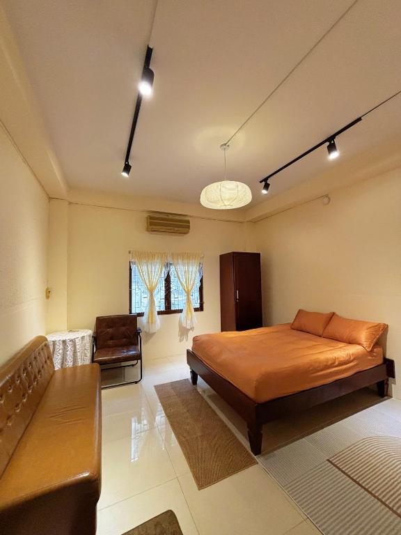 a bedroom with a bed and a couch in it at Thanh's Homestay in Ấp Bình Thới