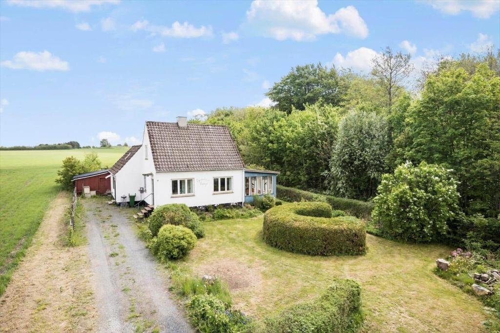 una piccola casa bianca in mezzo a un campo di 4767-Ostermarie-Olenevej-1 a Østermarie