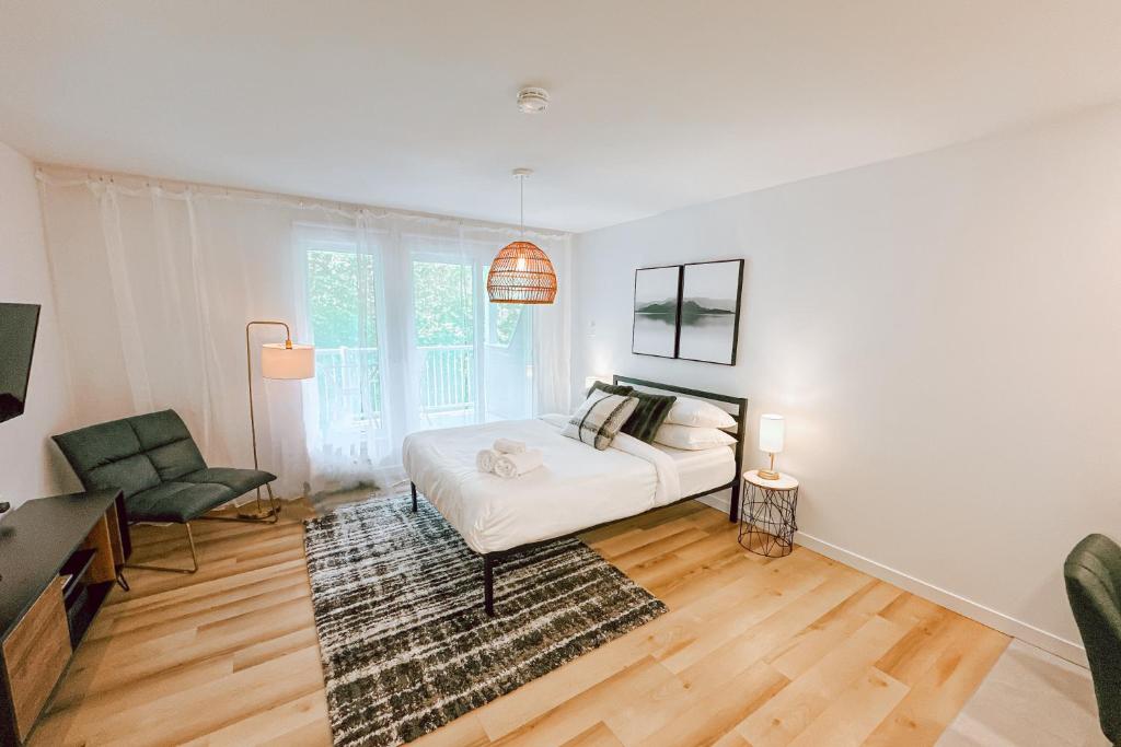 een woonkamer met een wit bed en een stoel bij Studio Resten by Gestion ELITE in Mont-Tremblant