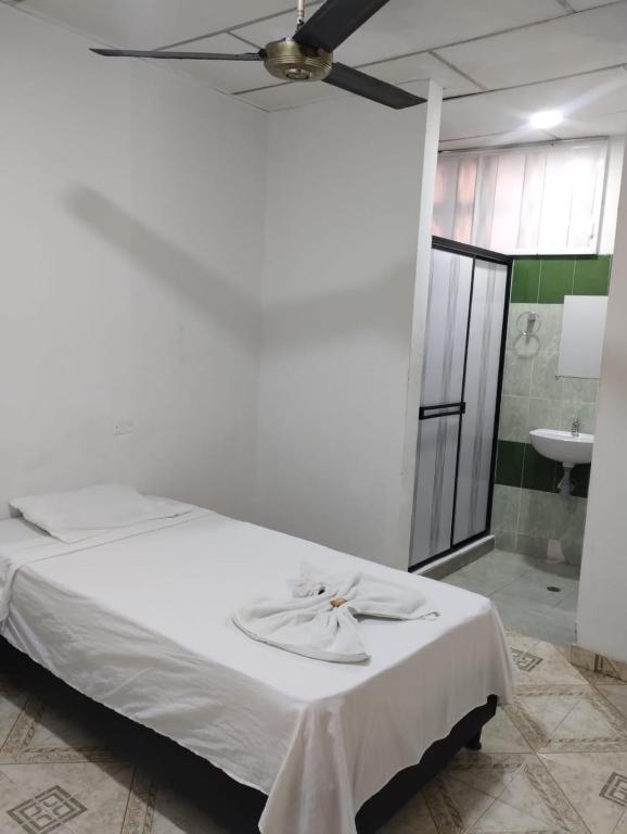 a bedroom with a white bed with a ceiling fan at La Quinta INN in Santa Marta
