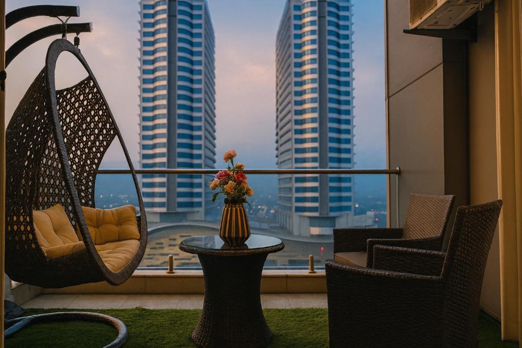 een balkon met stoelen en een tafel met uitzicht op de gebouwen bij Elysium Tower Prestige Premium Apartments Facing Centaurus Mall Islamabad in Islamabad