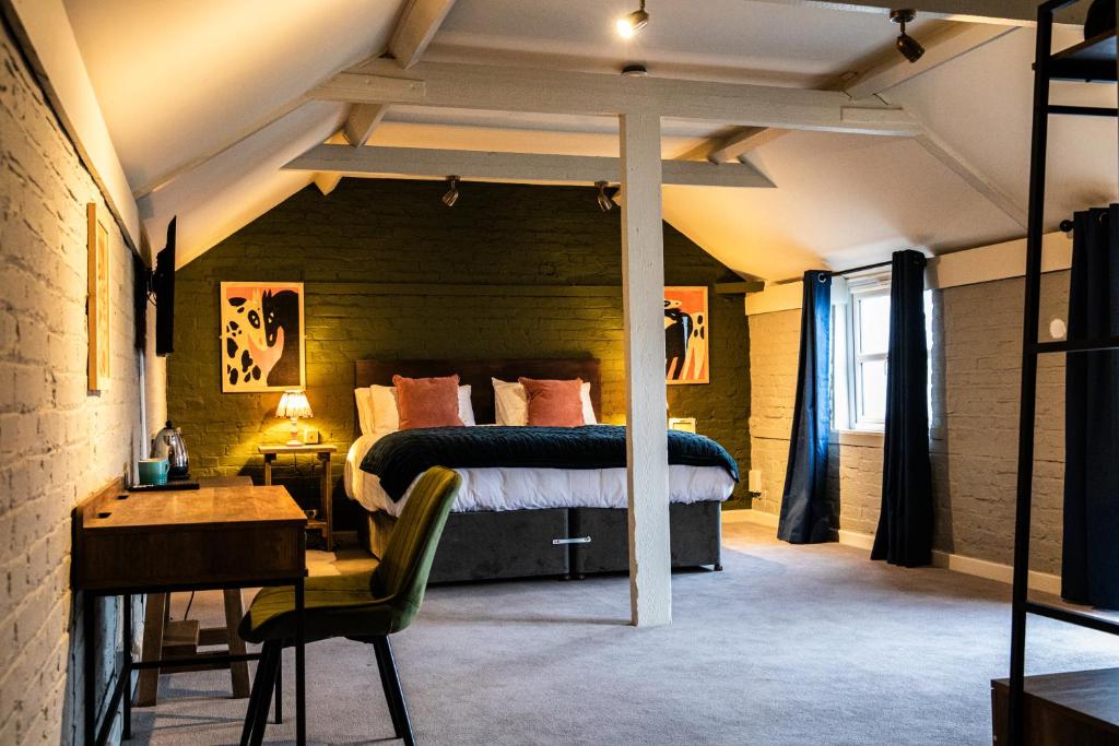 a bedroom with a bed and a desk with a chair at The Red Lion in Thames Ditton