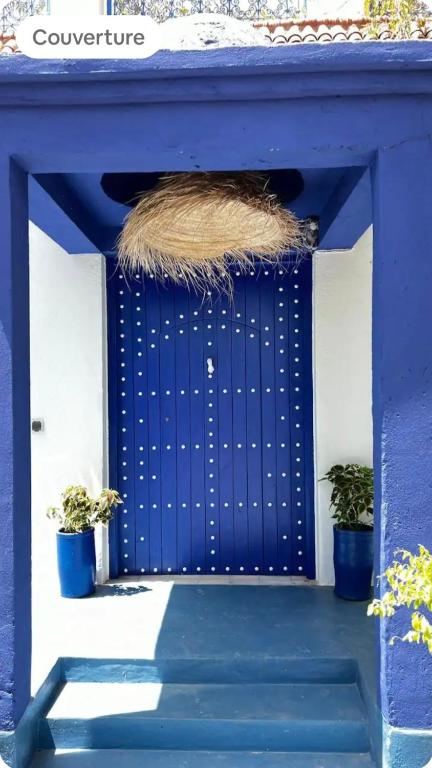 a blue door with a pile of hay at La kasbah bleue in Marrakesh