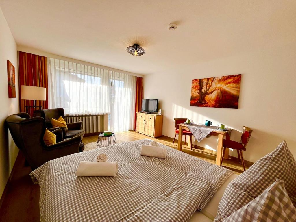 a bedroom with a bed and a living room at Nesthäkchen, Montana Haus in Oberstdorf
