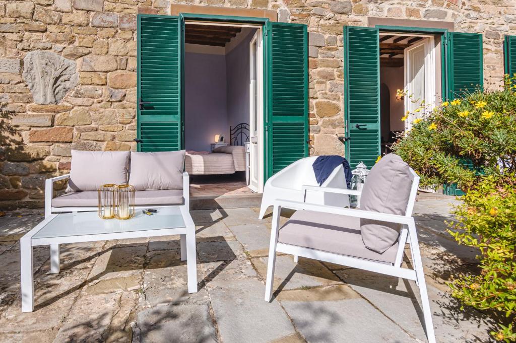 two white chairs and tables on a patio at Dimora Vecchio Duomo - Together in Tuscany in Cortona