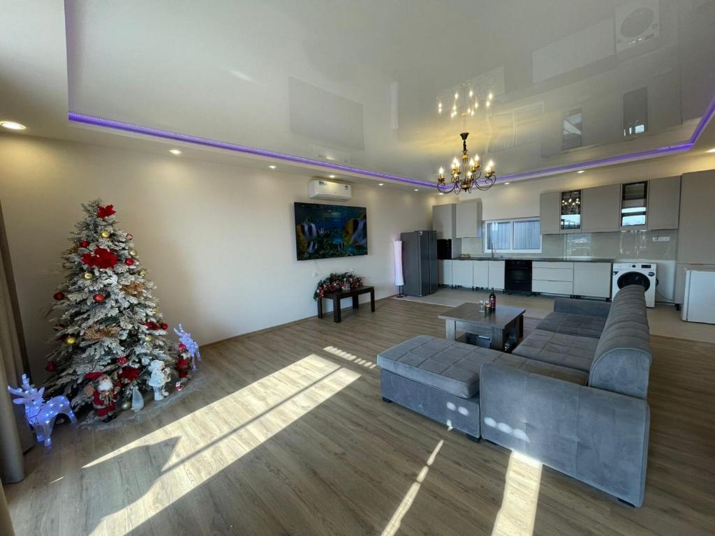 a living room with a christmas tree and a couch at Ejmiatsin To Zvartnots Airport in Yerevan