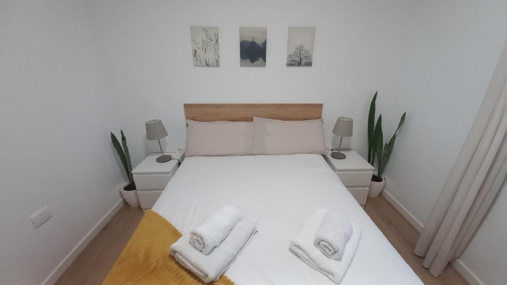 ein Schlafzimmer mit einem weißen Bett mit zwei Handtüchern darauf in der Unterkunft Villa Star in Agaete