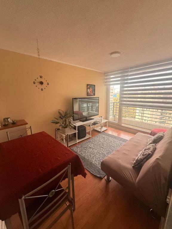 a living room with a bed and a flat screen tv at Alta vista Concepción in Concepción