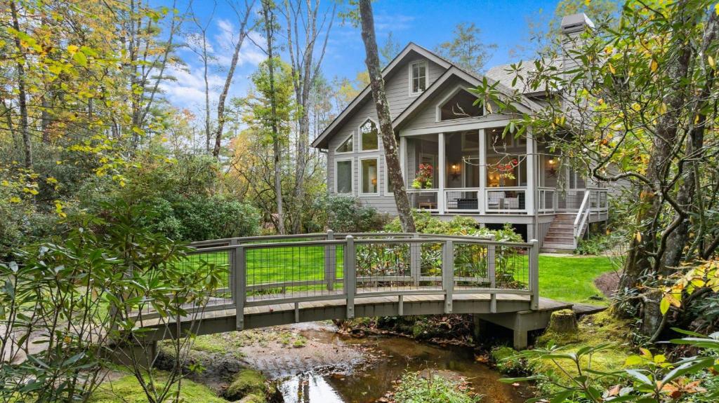 una casa con un ponte sopra un ruscello di Dancing Bear Walk to Town a Highlands