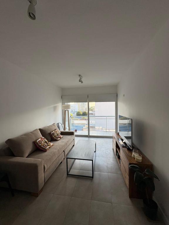 Alquiler temporal con cochera privada zona centro في تانديل: غرفة معيشة مع أريكة وتلفزيون