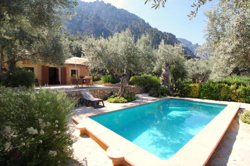 a swimming pool in a garden with a house at Casa Eva in Fornalutx
