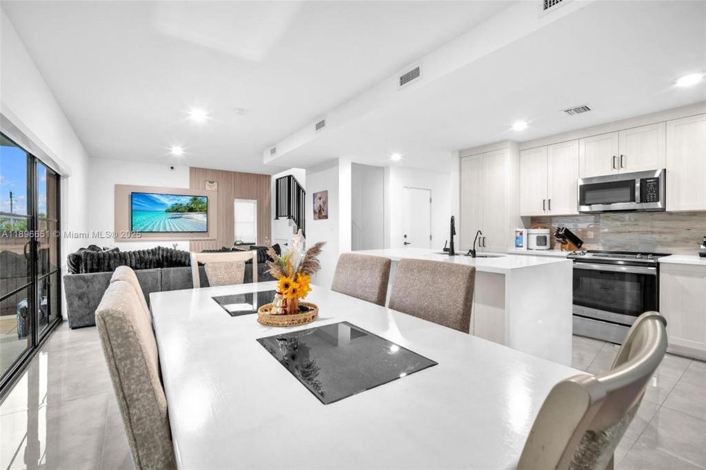 a kitchen and living room with a white table and chairs at Damari Soto in Florida City